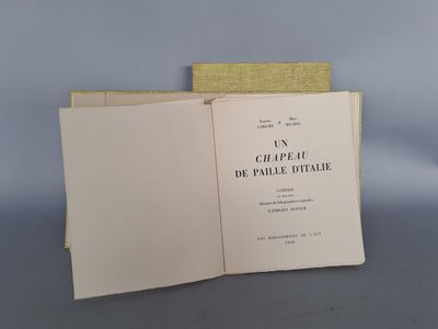 un livre ouvert posé sur une table à côté d'une pile de livres