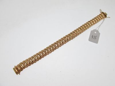 Gros plan sur un bracelet en or portant une étiquette
