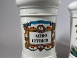 pair of ceramic jars with decorative designs on them on a white surface
