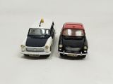 two toy cars sitting next to each other on a white surface
