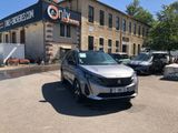 the silver car is parked in front of a building with a sign on it