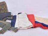 a pile of clothes and a gun on a white surface