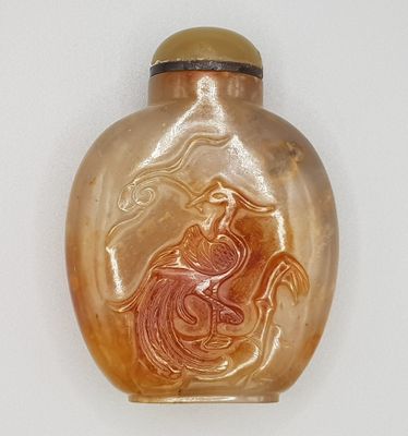 une bouteille en verre sur laquelle figure l'image d'une femme à cheval
