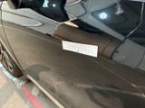 a sticker on the door of a car that is parked on the side of the road