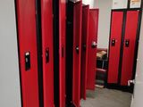 Plusieurs casiers rouges sont alignés les uns à côté des autres dans une pièce