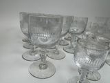 several empty wine glasses are lined up on a white surface