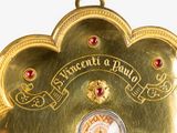 a gold clock with a picture of a man on it