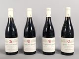 three bottles of red wine are lined up on a table