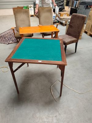 two chairs and a table in a warehouse with a man standing in the background