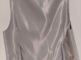 the back of a silver jacket hanging on a hanger