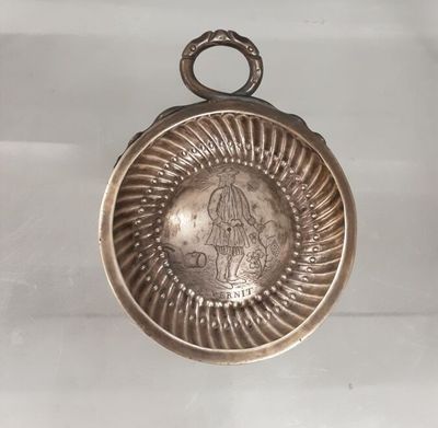 an old silver plate with a picture of a woman on it