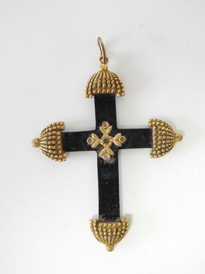 un gros plan d'une croix sur une surface blanche avec un fond blanc