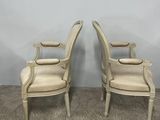 a pair of white chairs sitting on top of a carpeted floor