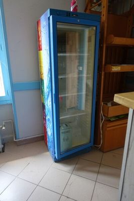 un réfrigérateur qui se trouve dans le coin d'une pièce