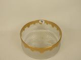 a glass bowl with a gold rim on a white surface
