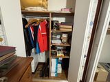 a closet with a lot of clothes and books in it