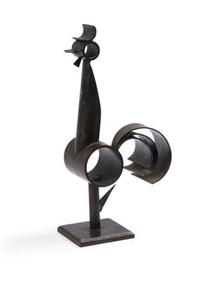 une sculpture métallique représentant un oiseau posée sur un socle