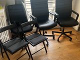 quatre chaises de bureau noires dans une pièce dotée d'une fenêtre et d'un radiateur