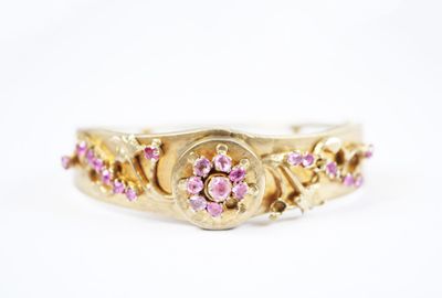 une bague en or jaune sertie de saphirs roses et de diamants
