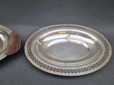 two silver plates that are on a wooden stand