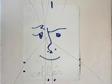drawing of a face on a piece of paper with writing on it