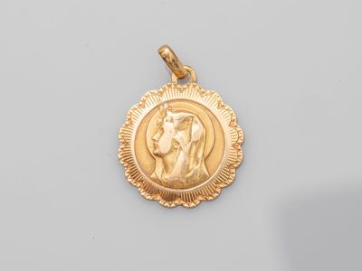 un pendentif en or sur lequel est représenté Jésus