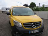 une camionnette jaune garée sur un parking à côté d'une camionnette blanche