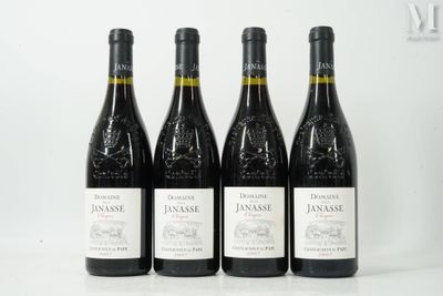 quatre bouteilles de vin sont alignées sur une surface blanche