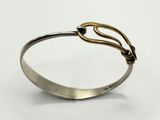 a close up of a silver and gold bracelet with a knot on it