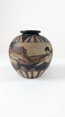 a small vase with a painting on it on a white surface