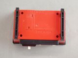 a close up of a red nintendo game console sitting on top of a table