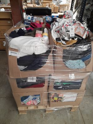 de nombreux cartons de vêtements posés sur une palette dans un entrepôt