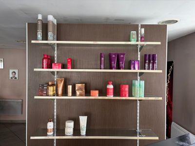 une étagère sur laquelle sont disposés de nombreux produits capillaires de toutes sortes