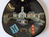 a black plate with a picture of a clock on it