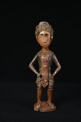 une figurine en bronze représentant un homme coiffé d'un chapeau et les mains sur les hanches
