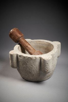 mortar with a wooden stick in it on a gray background