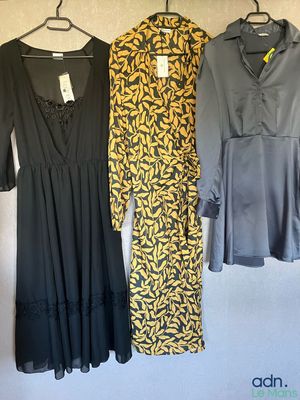 three dresses hanging on a clothes rack in a room