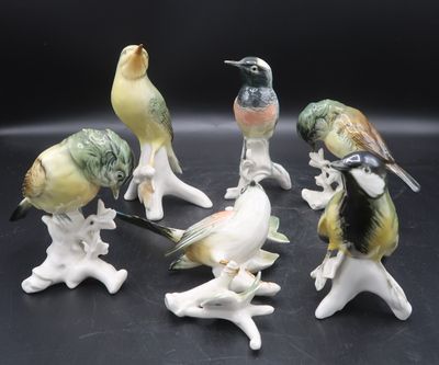 six figurines of birds sitting on top of each other on a black surface