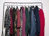 a lot of clothes hanging on a rack in a room