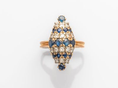 gros plan d'une bague en diamant et saphir sur une surface blanche