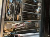 a drawer full of utensils and other kitchen utensils