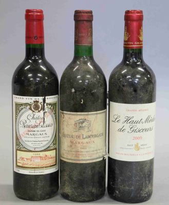 trois bouteilles de vin sont alignées sur une surface blanche