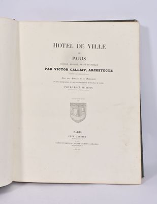 un livre ouvert posé sur une table à côté d'un mur blanc
