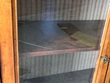 an old wooden cabinet with glass doors and a door handle