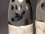 two bottles of wine sitting next to each other on top of a table