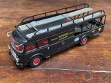 un petit bus en plastique posé sur une table en bois