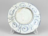 blue and white plate with a circular design on a stand