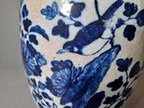 a blue and white vase with a bird on it