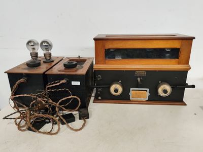 une radio à l'ancienne et d'autres objets sont posés sur une surface blanche