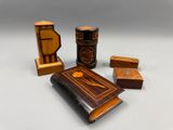 trois petites boîtes en bois et un livre posés sur une surface blanche